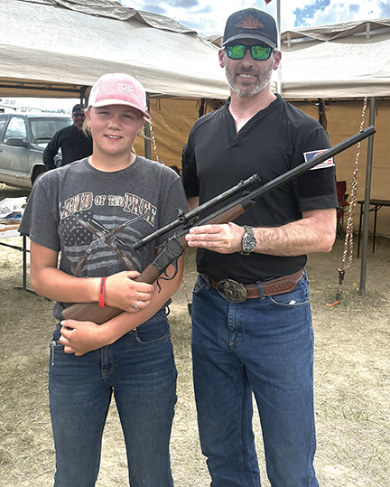 Zach Schoffstall presents the youth rifle to Taya Hoaglund.